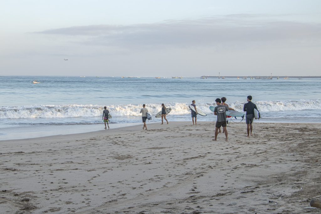 Surfers entering the water at Jimbaran beach