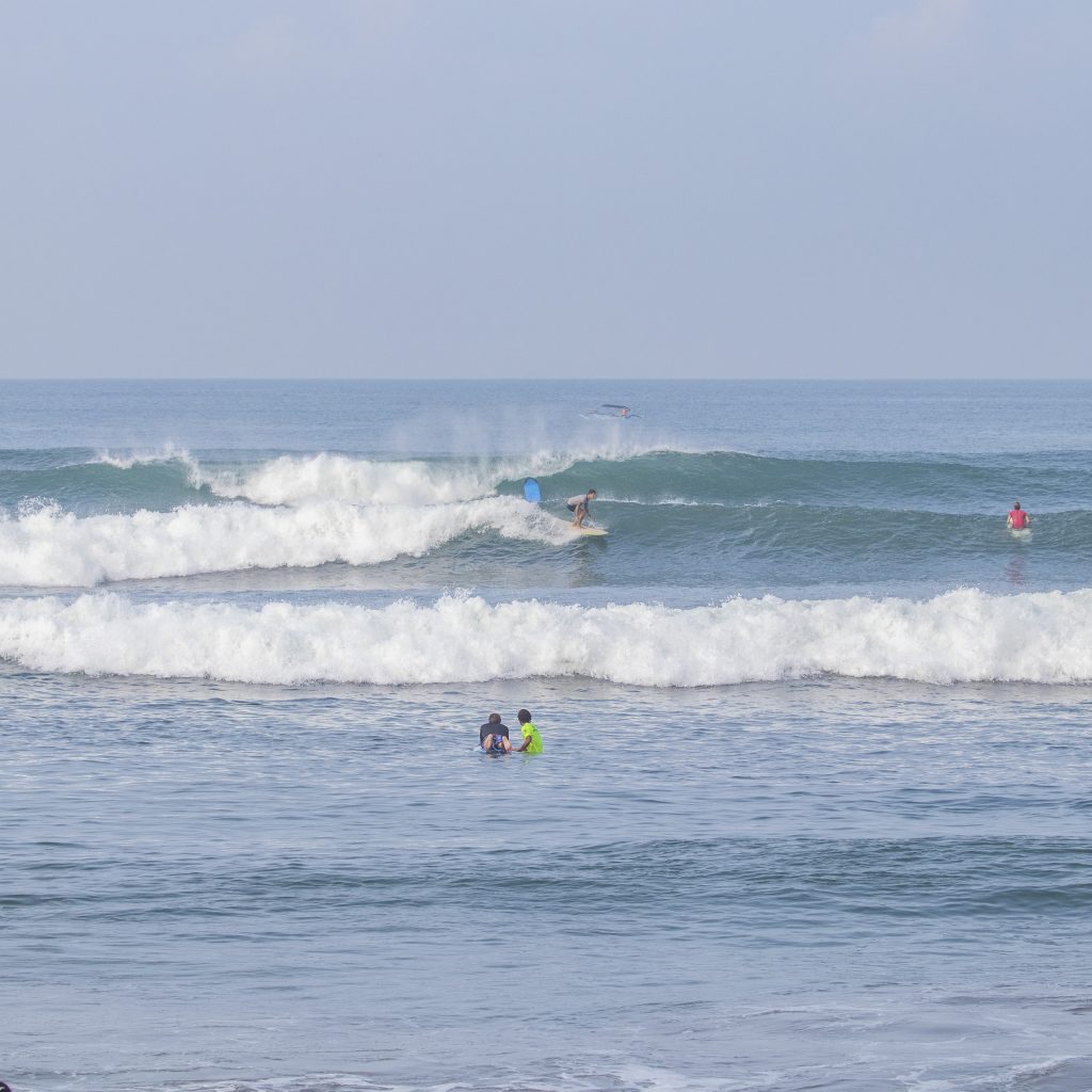 Surfers riding waves at Batu Belong.