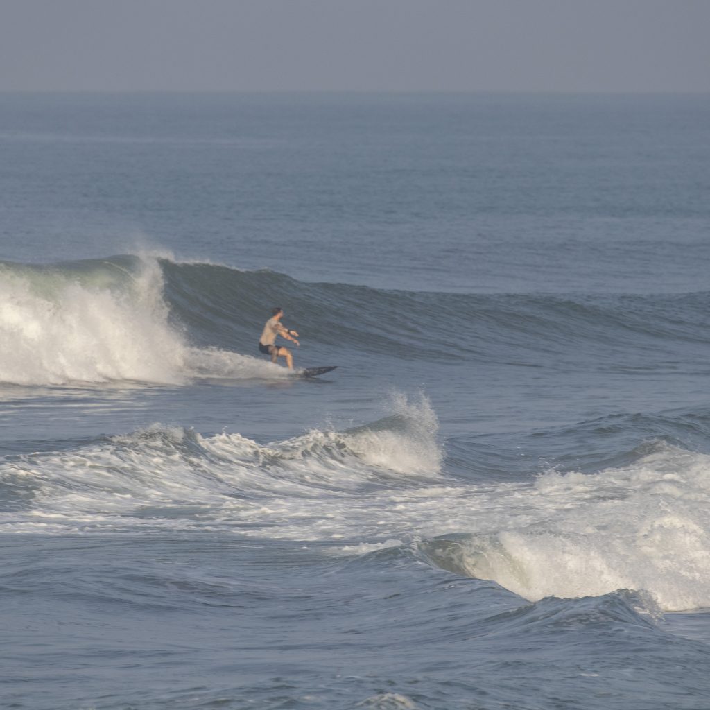A surfer riding a wave at Pererenan.