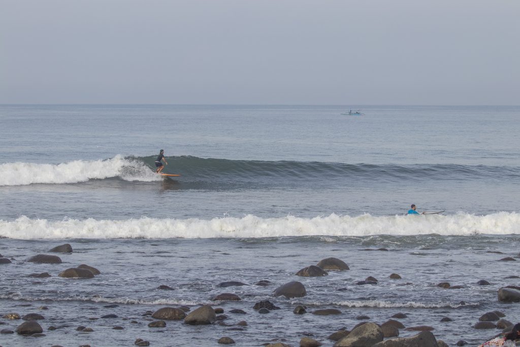 Surfer on a small wave at Medewi