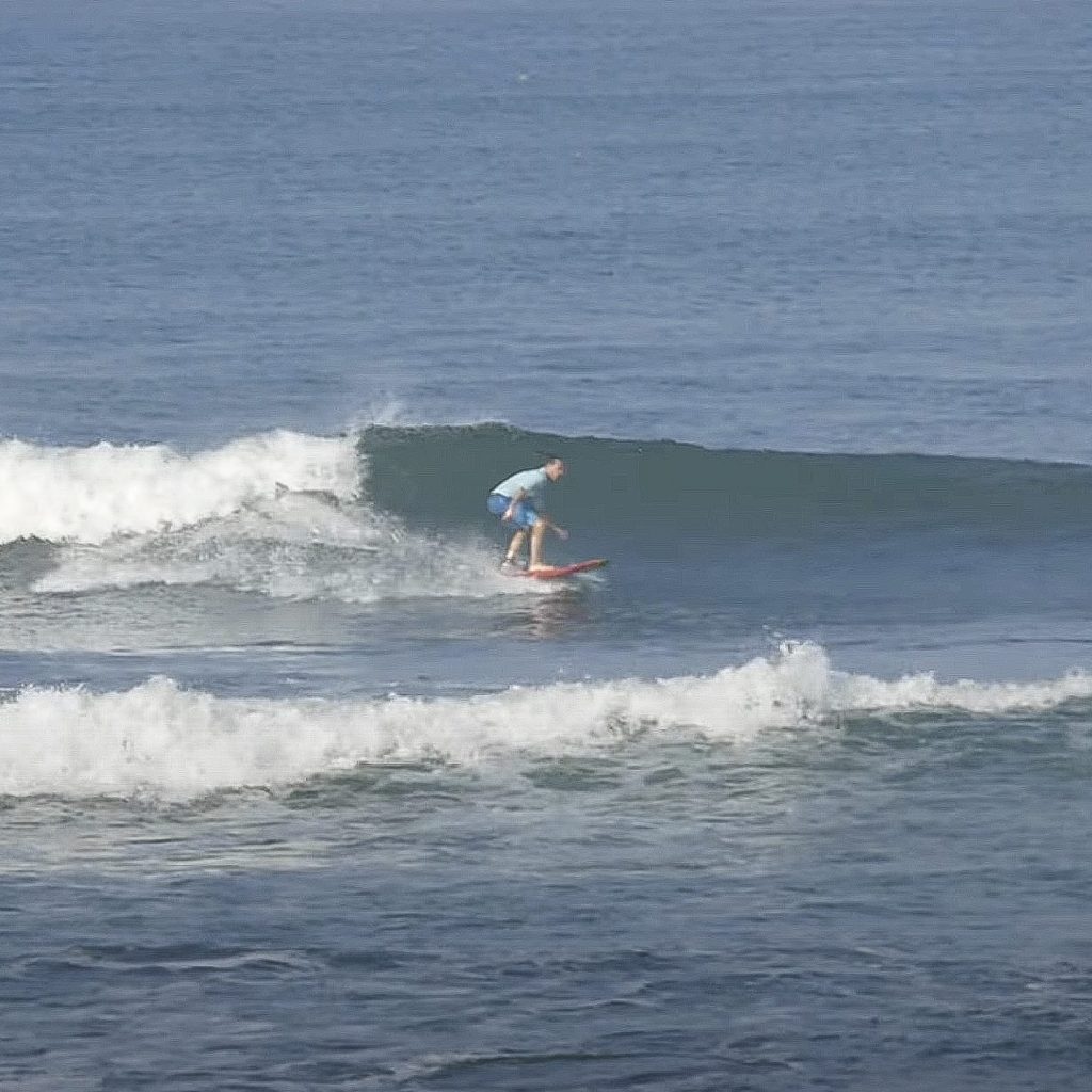 Surfer riding a wave at kedungu.