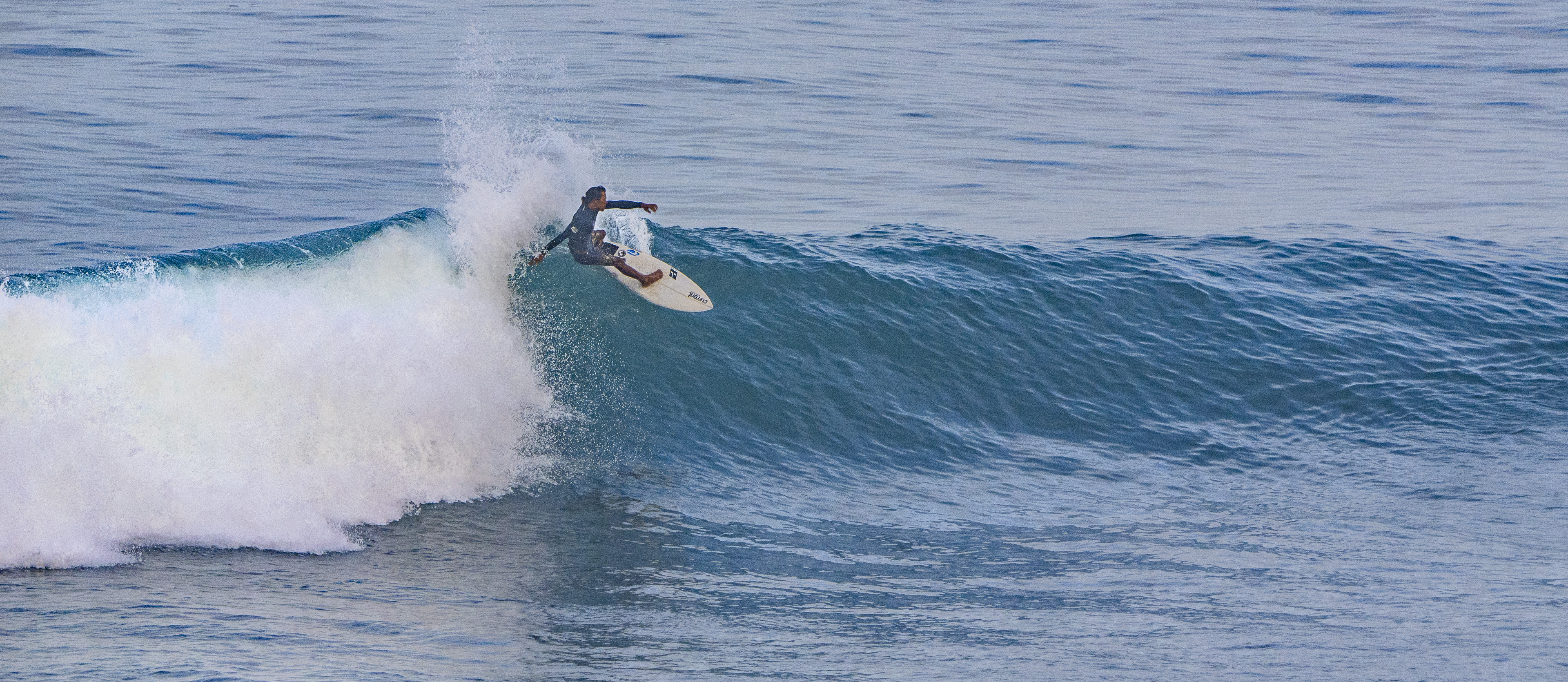 Surfer doing a top turn on a wave.