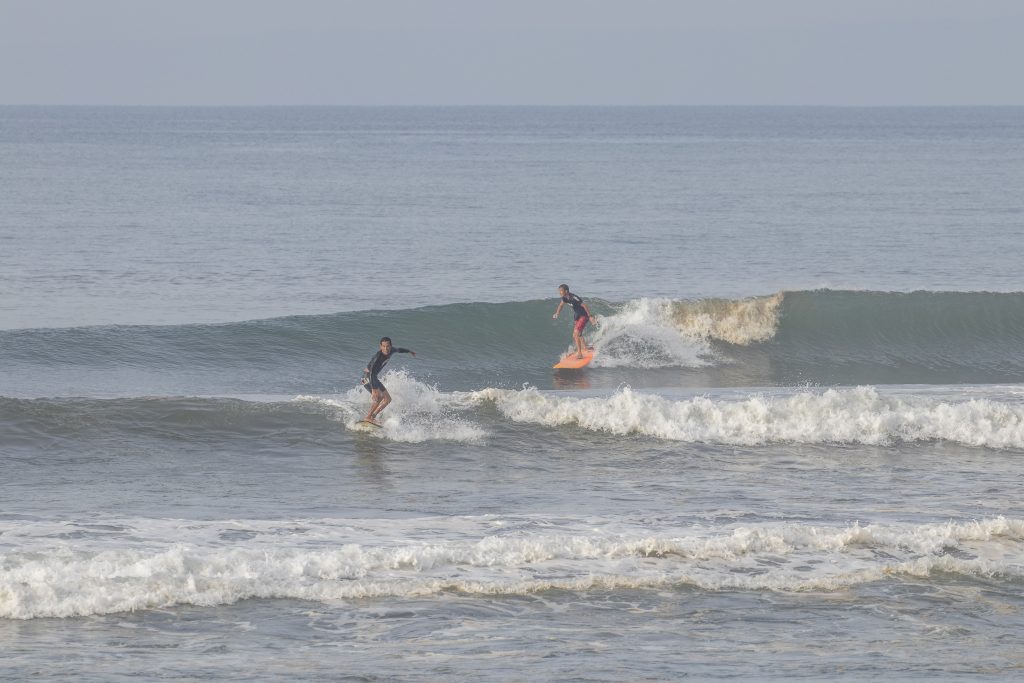 Surfers riding waves at Yeh Sumbul.